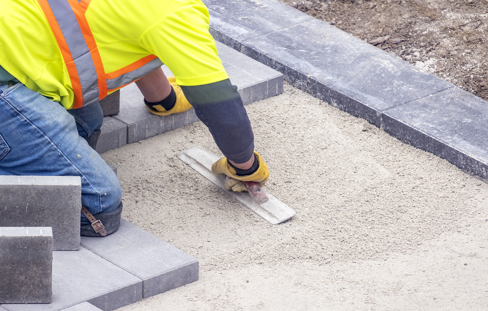  Workman in Safety Jacket Preparing the Foundation of Patio Pavement in Kansas City MO